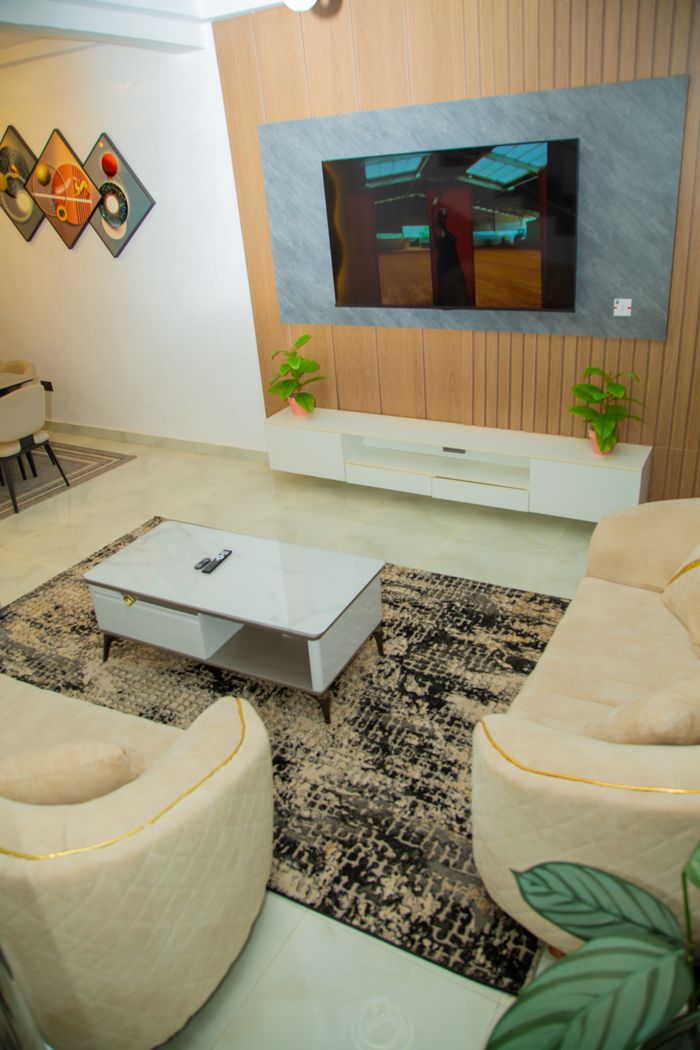 Stylish modern living room featuring a TV, chic furniture, and minimalist art decor.